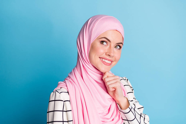 Close-up profile side view portrait of lovely minded cheery muslimah girl touching chin thinking isolated over shine blue color background. - Fotó, kép