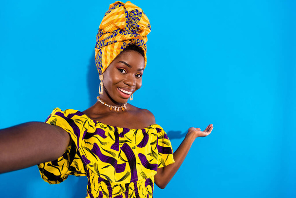 Photo of young pretty cheerful smiling african woman in traditional turban take selfie invitation isolated on blue color background. - Photo, image