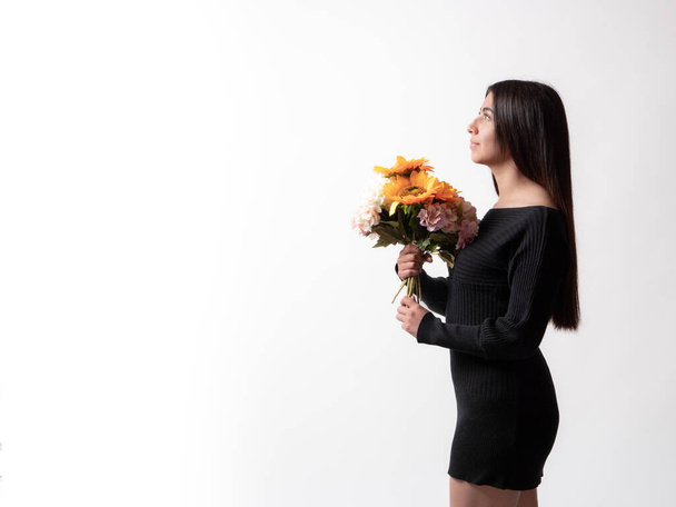 mooi latina meisje met een boeket van zonnebloemen, geïsoleerd op witte achtergrond, Moederdag cadeau concept. - Foto, afbeelding