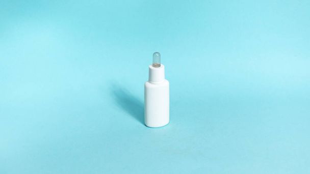 One white tube of skin care cosmetics on blue background. The concept of face and body skin care and anti-aging treatments. Copy space. Flat lay. - Фото, изображение