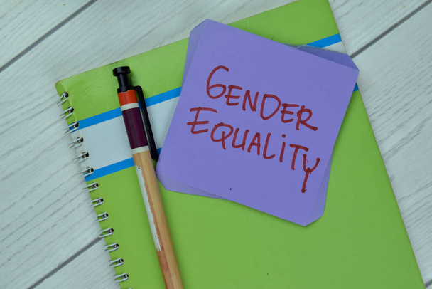 Έννοια της ισότητας των φύλων γράφουν σε αυτοκόλλητες σημειώσεις που απομονώνονται σε ξύλινο τραπέζι. - Φωτογραφία, εικόνα