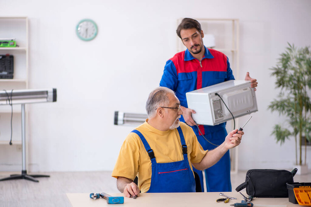 Dos reparadores trabajando en el taller - Foto, imagen