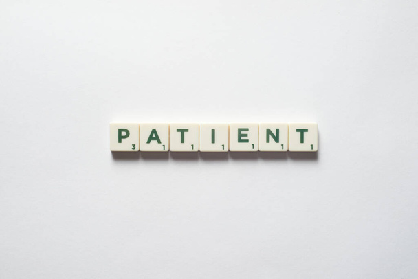 Patient word formed of scrabble blocks on white backdrop. Medical examining and physical health awareness. - Foto, imagen