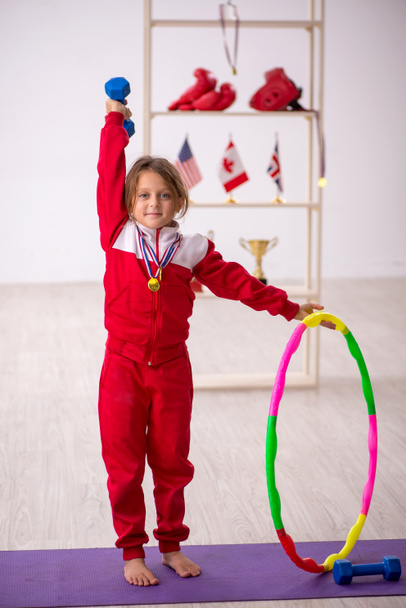 Young small girl doing sport exercises at home - Photo, Image