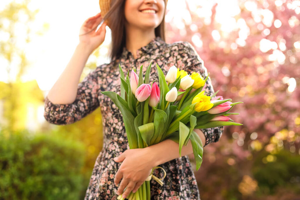 Young woman with bouquet of tulips in park on sunny day, closeup - Φωτογραφία, εικόνα