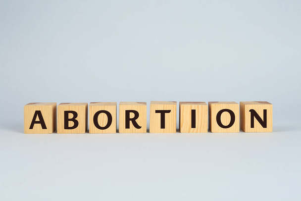 Word Abortion made of wooden cubes on light grey background - Фото, зображення