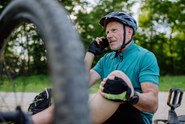 An active senior man calling for help after his bicycle accident. - Valokuva, kuva