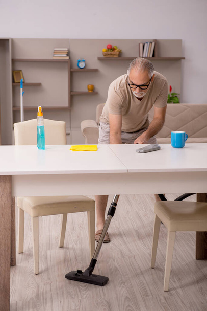 Älterer Mann erledigt Hausarbeit zu Hause - Foto, Bild