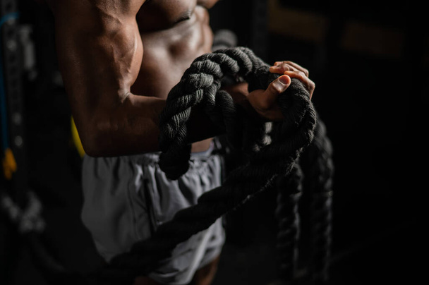 Muscular african american man posing with rope in gym - Foto, imagen