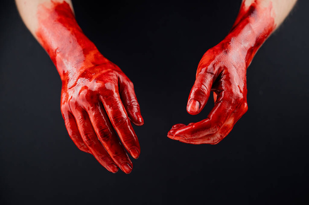 Womens hands in blood on a black background - 写真・画像