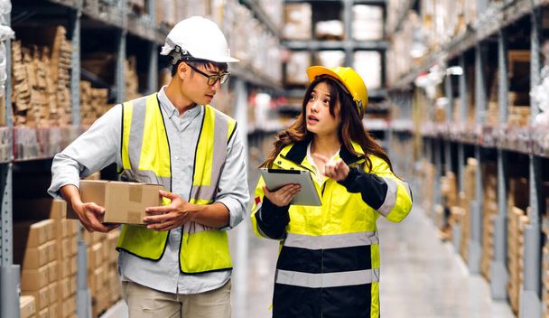 Asian two engineer team shipping order detail on tablet check goods and supplies on shelves with goods background inventory in factory warehouse.logistic industry and business export - Foto, immagini