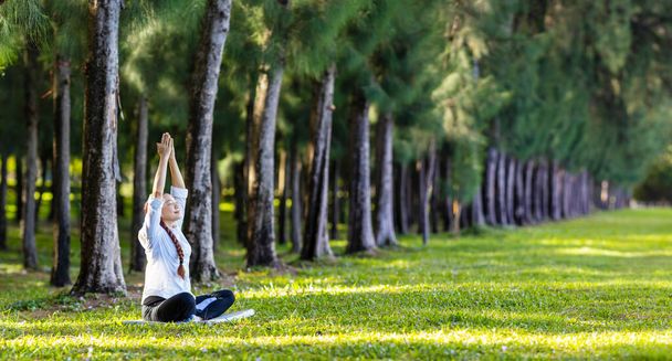 Mujer practicando relajadamente meditación de yoga en el bosque de pinos para alcanzar la felicidad desde la paz interior sabiduría para la mente y el alma saludables - Foto, Imagen