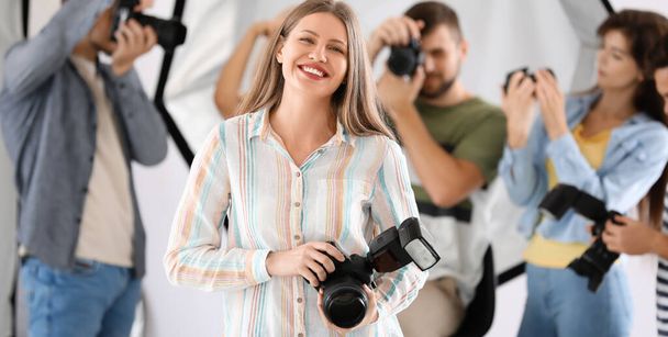 Portrait of pretty female photographer in studio - Фото, зображення