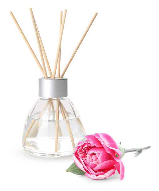Reed diffuser en pioenroos bloem op witte achtergrond - Foto, afbeelding