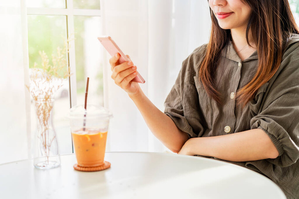 Young woman with drinks using mobile phone and relaxing in cafe, Modern lifestyle - Photo, image