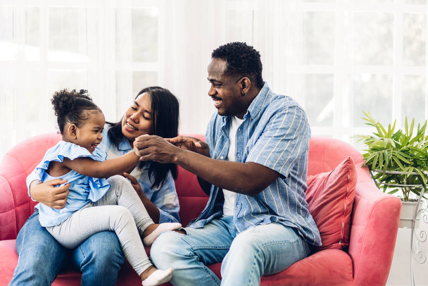 Mutlu aşk portresi Afro-Amerikan aile Afrikalı baba ve anne ve küçük Afrikalı kız çocuk gülümseyerek ve evde iyi vakit geçirerek eğleniyorlar. - Fotoğraf, Görsel