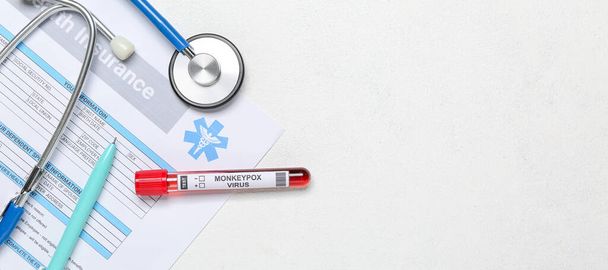 Monkeypox virus sample, health insurance blank and stethoscope on white background - Photo, image