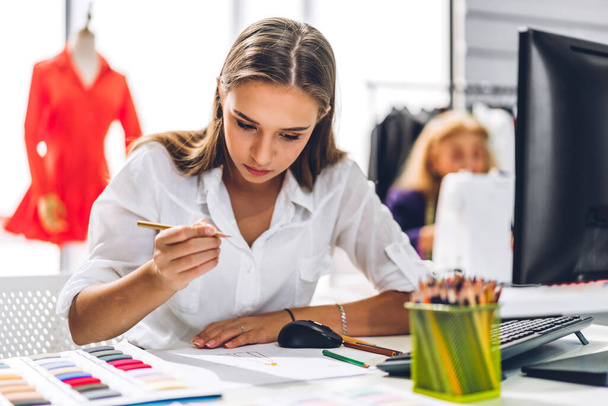 Portrait of young beautiful pretty owner business woman fashion designer stylish sitting and working.Attractive young designer girl use desktop conputer and colorful fabrics at fashion design workshop studio - Foto, Imagen
