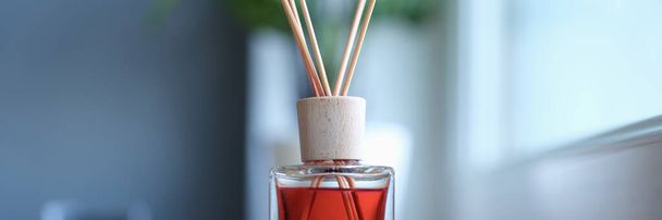 Bamboe sticks geur voor de kamer staat in de buurt van het raam, close-up, wazig. Verspreid de geur. Aromatherapie - Foto, afbeelding