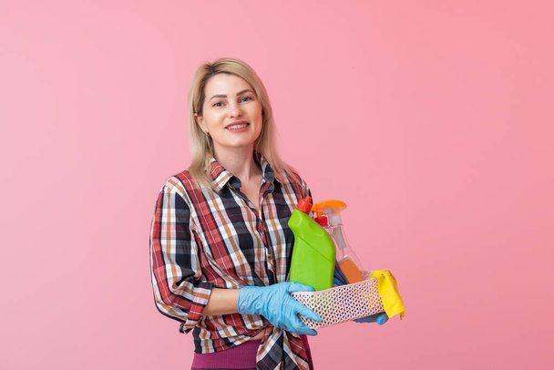 Hermosa mujer rubia sosteniendo cesta y botella de detergente - Foto, Imagen