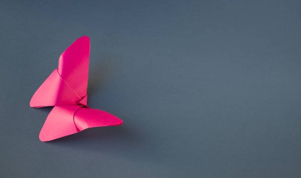 Pink paper butterfly origami isolated on a blank grey background. - Fotó, kép