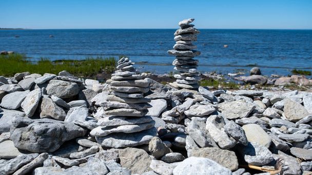 Figuras de piedra en la playa de la Península de Sorve en la Reserva Natural de Ojessaare. Estonia, Saaremaa. Horizonte sobre el mar en verano. Playa de guijarros - Foto, Imagen