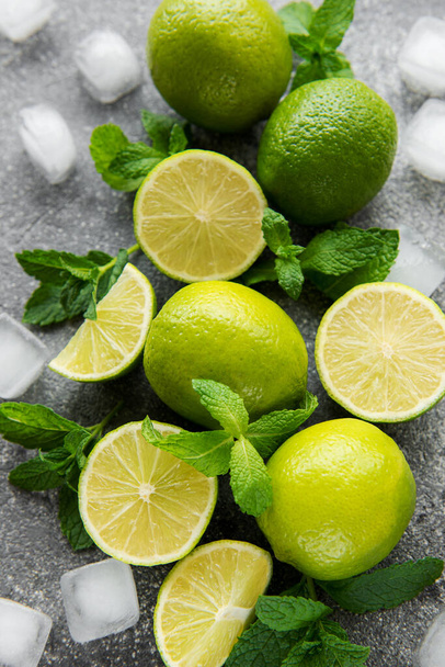 Lime and mint on a dark background. The ingredients for making refreshing drinks and cocktails. - Fotografie, Obrázek