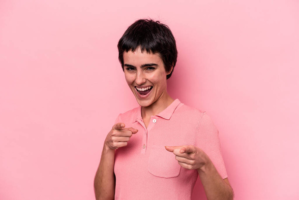 Young caucasian woman isolated on pink background pointing to front with fingers. - Foto, Imagem