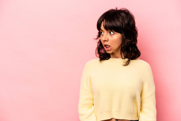 Young hispanic woman isolated on pink background being shocked because of something she has seen. - Photo, Image