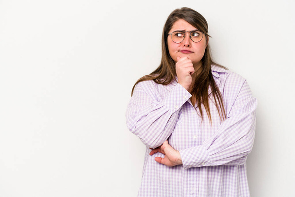 Young caucasian overweight woman isolated on white background looking sideways with doubtful and skeptical expression. - Photo, Image