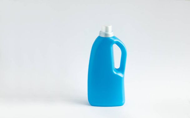 Blue plastic bottle stands on white background. Conditioner or liquid powder for washing. Capacity with space for copying. Layout for logo application - Fotó, kép