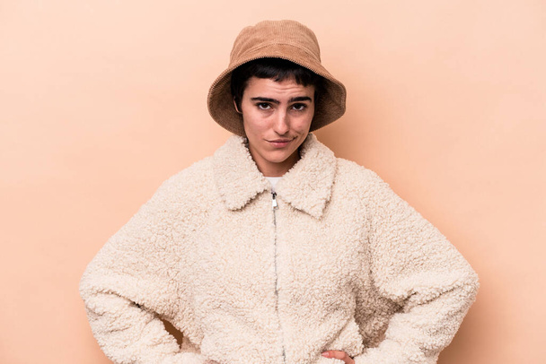 Young caucasian woman isolated on beige background sad, serious face, feeling miserable and displeased. - Φωτογραφία, εικόνα