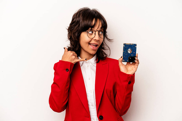 Jeune femme hispanique informatique isolée sur fond blanc montrant un geste d'appel téléphonique mobile avec les doigts. - Photo, image