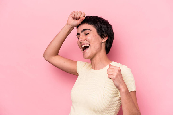 Young caucasian woman isolated on pink background celebrating a special day, jumps and raise arms with energy. - Zdjęcie, obraz