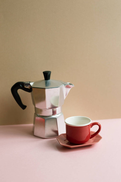 https://cdn.create.vista.com/api/media/small/582220332/stock-photo-italian-coffee-maker-mocha-coffee-pot-cup-pink-table-beige