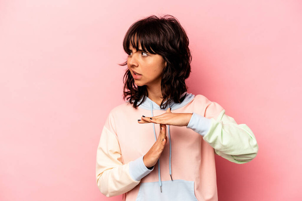 Young hispanic woman isolated on pink background showing a timeout gesture. - Zdjęcie, obraz