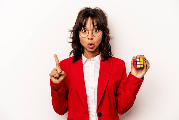 Νεαρή επιχειρηματίας κρατώντας κύβο Rubiks απομονωμένη σε λευκό φόντο έχοντας κάποια μεγάλη ιδέα, την έννοια της δημιουργικότητας. - Φωτογραφία, εικόνα