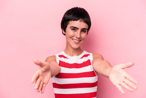 Young caucasian woman isolated on pink background showing a welcome expression. - Foto, Imagem