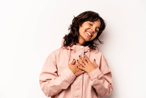 Young hispanic woman isolated on white background laughing keeping hands on heart, concept of happiness. - Фото, изображение