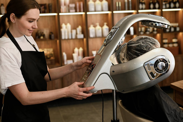 young woman under hooded dryer machine in hair salon - Foto, Imagem