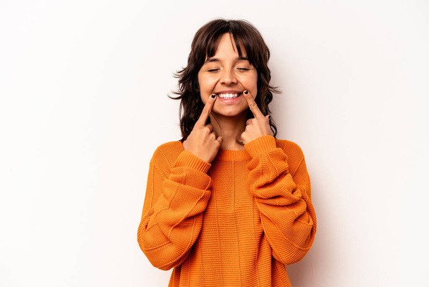 Молода іспаномовна жінка ізольована на білому тлі посміхається, вказуючи пальці в рот
. - Фото, зображення