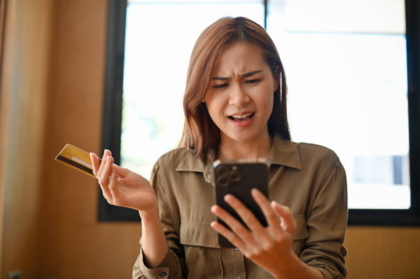 Güzel genç Asyalı kadın mutsuz, online alışveriş başvurusundan memnun değil, internet bankacılığı hizmeti ile ilgili sorunları var.. - Fotoğraf, Görsel