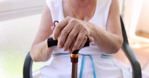Zbliżenie rąk starszej kobiety z laską w domu opieki. Pomoc starszej generacji koncepcji - Materiał filmowy, wideo