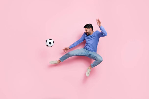 Full length photo of pretty funky man wear long sleeve shirt jumping high playing football isolated pink color background. - 写真・画像