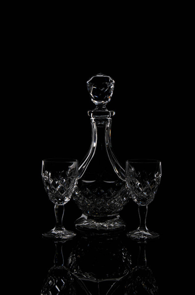 A vertical shot of decanter and glasses isolated in black background - Foto, afbeelding