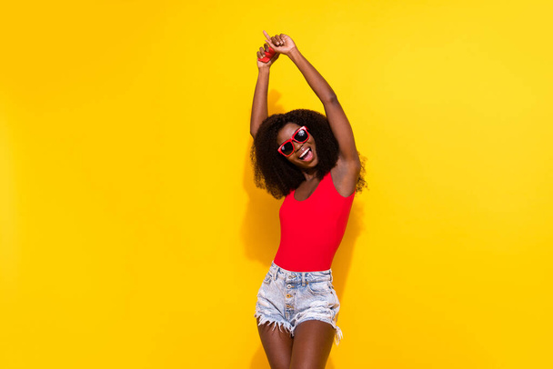 Portrait of attractive ecstatic cheerful girl dancing vacation holiday rest relax rising hands up isolated over bright yellow color background. - Photo, image
