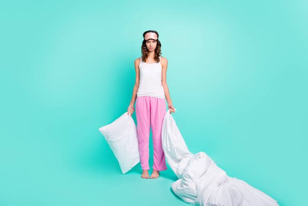 Photo of sad depressed young woman sleepwear holding pillow duvet isolated turquoise color background. - Foto, imagen