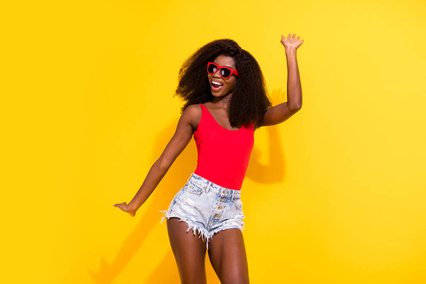 Portrait of attractive cheerful carefree girl having fun dancing chill out good mood clubbing isolated over bright yellow color background. - Foto, Bild