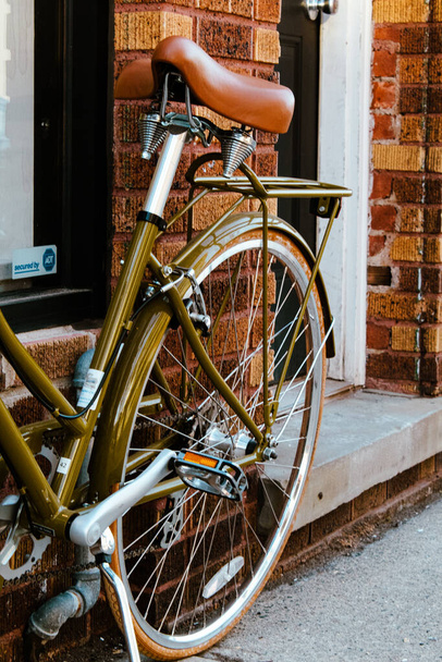 A bicycle with a brown leather seat near a stone building - Photo, Image