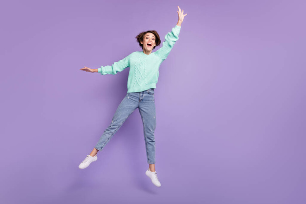 Full length photo of young excited girl happy positive smile jump try to catch umbrella isolated over violet color background. - Фото, зображення